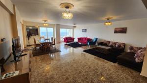uma sala de estar com um sofá, cadeiras e uma mesa em Sea View Heart Apartment (families only) em Alexandria