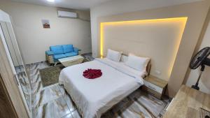 Un dormitorio con una cama blanca con una flor roja. en Sea View Heart Apartment (families only) en Alexandria