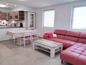 sala de estar con sofá rojo y mesa en Szandra Apartmanház, en Gyenesdiás