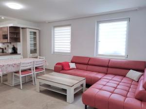 sala de estar con sofá rojo y mesa en Szandra Apartmanház, en Gyenesdiás