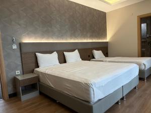 2 camas en una habitación de hotel con 2 camas en Niconya Port Suite&Hotel, en Estambul