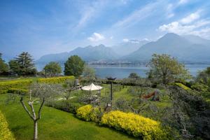 a garden with a view of a lake and mountains at Villa Costanza- private heated pool, steam room & sauna - Bellagio Village Residence in Oliveto Lario