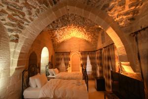 Legacy Mesopotamia Hotel في ماردين: غرفة نوم بسريرين في جدار حجري