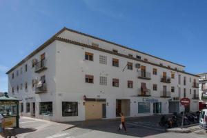 una mujer caminando delante de un edificio blanco en Habitación cerca de todo en casa de Emilia, en Altea