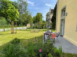 un jardín con una mesa y un banco en un patio en Klosterloft - Modernes Apartment in historischer Klosteranlage, en Ravensburg