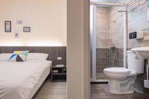 een badkamer met een bed, een douche en een toilet bij 樂洋洋民宿 in Magong