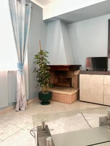 a living room with a fireplace and a tv at La Casa di Wioletta in Barcellona-Pozzo di Gotto