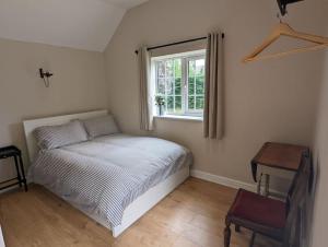 a small bedroom with a bed and a window at The Annexe at Entry House in Quadring