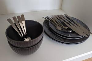 two black plates and silver utensils on a counter at The Annexe at Entry House in Quadring