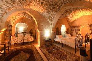 a bedroom with two beds in a brick wall at Legacy Mesopotamia Hotel in Mardin