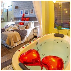 a room with a bath tub and a bed at Pousada Natribus Rosa in Praia do Rosa