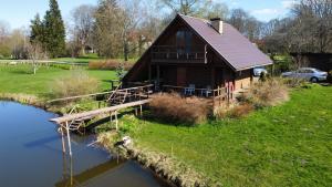 a log cabin with a bridge over a river at Mežvītoli in Mercendarbe +9 photos