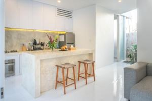 een keuken met een aanrecht en krukken in een kamer bij White butterfly Villa, Kitchen & Pool, Quiet Ubud in Ubud