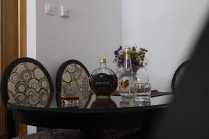 twee flessen alcohol en twee glazen op een tafel bij Apartman Mama in Trebinje