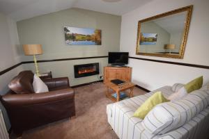a living room with two couches and a fireplace at Burnthwaite Cottage in Windermere