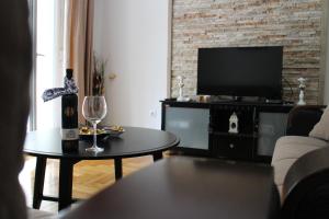 een woonkamer met een bank, een tv en een tafel bij Apartman Mama in Trebinje