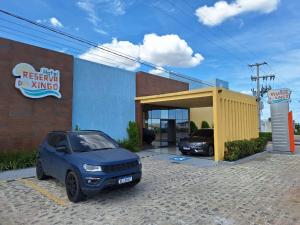 Hotel Reserva do Xingó في ببرانا: سيارة زرقاء متوقفة أمام كراج