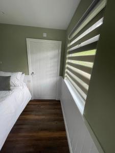 a bedroom with a white bed and a window at Tyddyn Bach Bunkhouse in Betws-y-coed