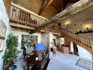 Duży pokój z drewnianymi schodami i stołem w obiekcie Maison des gardiens du château w mieście Béru