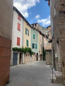 Une allée avec des bâtiments colorés dans une ville dans l'établissement Agréable maison de village., à Castellane