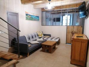 a living room with a couch and a table at Agréable maison de village. in Castellane