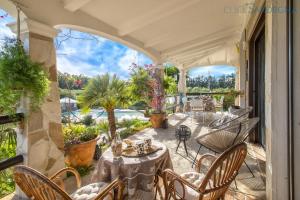 un patio con mesas y sillas en el balcón en Maison du Bonheur Exclusive Retreat for Peace of Mind, en Olmedo