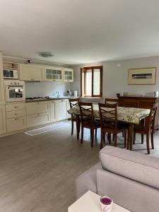 Spazio Friuli - Tiare Apt. residenza nel verde في Sevegliano: مطبخ وغرفة طعام مع طاولة وكراسي