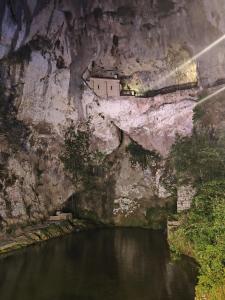 un edificio al lado de un acantilado junto a un río en Hotel El Repelao, en Covadonga