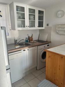 a kitchen with a sink and a washing machine at Panorama Mer in Saint Pierre La Mer