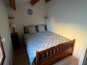 1 dormitorio con 1 cama y reloj en la pared en Panorama Mer, en Saint Pierre La Mer