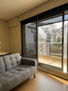 sala de estar con sofá y ventana grande en 3-6 Hermoso Monoambiente baño privado en Buenos Aires