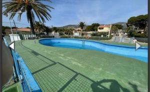 a swimming pool with a fence and a tennis court at Villa ALCANAR PLATJA in Les Cases d'Alcanar