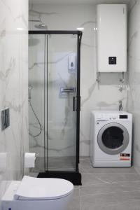 a bathroom with a toilet and a washing machine at Trebinje Lux Apartment in Trebinje