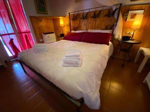 una camera da letto con un grande letto con asciugamani di Casa Vista lago - 24h Check in - Free WiFi - Netflix a Monte Isola
