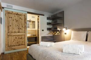 Schlafzimmer mit einem Bett und einer Schiebetür in der Unterkunft Visaisa taverna & foresteria in Acceglio