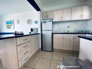 a kitchen with wooden cabinets and a stainless steel refrigerator at Mandy's kaliva Club Mykonos in Langebaan