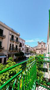 a green railing in a city with buildings at "La Madrice" Casa Vacanze in Bagheria