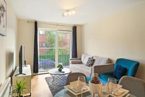 een woonkamer met een bank en een tafel bij Fully Furnished 2 BR Flat with Free Parking in Stoke on Trent