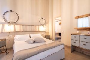 a bedroom with a bed with two pillows and a mirror at Agriturismo Sweet Cottage in Marina di Grosseto