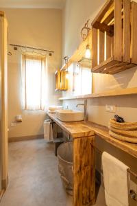 La salle de bains est pourvue d'un lavabo et d'un miroir. dans l'établissement Agriturismo Sweet Cottage, à Marina di Grosseto
