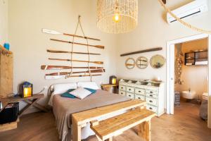a bedroom with a bed with a bench and a chandelier at Agriturismo Sweet Cottage in Marina di Grosseto