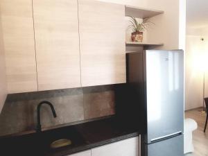 una cocina con fregadero y refrigerador en La Casina di Nonna Giulia, en Castiglione dʼOrcia