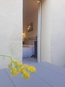 Habitación con dormitorio con cama y flores amarillas en La Casina di Nonna Giulia, en Castiglione dʼOrcia