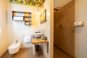 a bathroom with a sink and a toilet and a mirror at Agriturismo Sweet Cottage in Marina di Grosseto