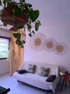 a living room with a white couch and potted plants at Barra Apart Service in Salvador