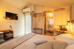 a bedroom with a large bed and a television at Agriturismo Sweet Cottage in Marina di Grosseto