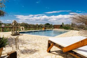 a swimming pool with a bed and a bench at Agriturismo Sweet Cottage in Marina di Grosseto