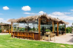 a building with a thatched roof and a table at Agriturismo Sweet Cottage in Marina di Grosseto