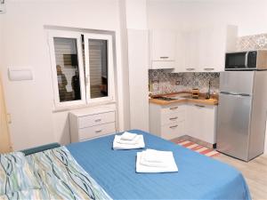a kitchen with a blue table with towels on it at Parco dei Gerani - Il monolocale e la camera - Room and Studio in Formia