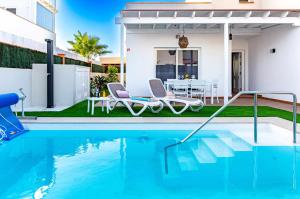 basen z dwoma krzesłami i dom w obiekcie Villa Sea Sounds w Corralejo